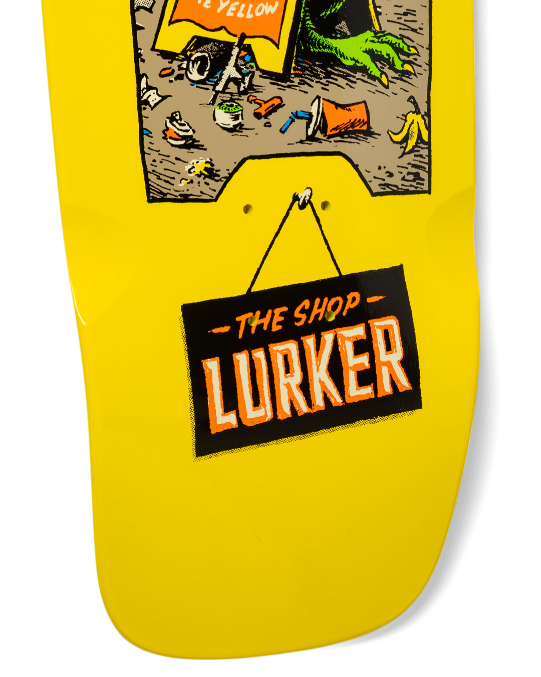 Yellow skateboard deck with 'The Shop Lurker' branding and graphic design.