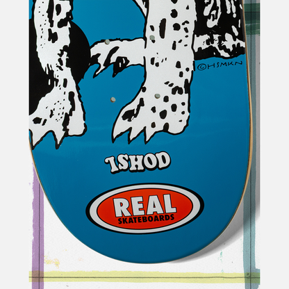 Skateboard deck with a blue background, white paw prints, and 'Real Skateboards' logo.